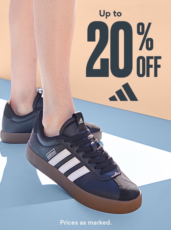 up to 20% off adidas. feet of person wearing black adidas court sneakers