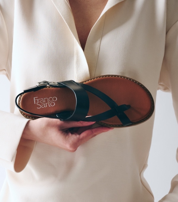 woman holding black franco sarto sandal