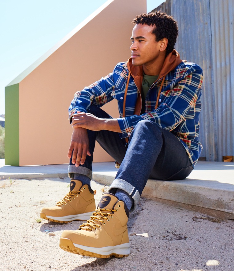 man in jeans and flannel sitting down wearing nike manoa boots