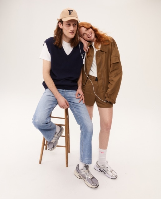 man on a stool wearing Nike shoes and woman leaning on him wearing Nike shoes