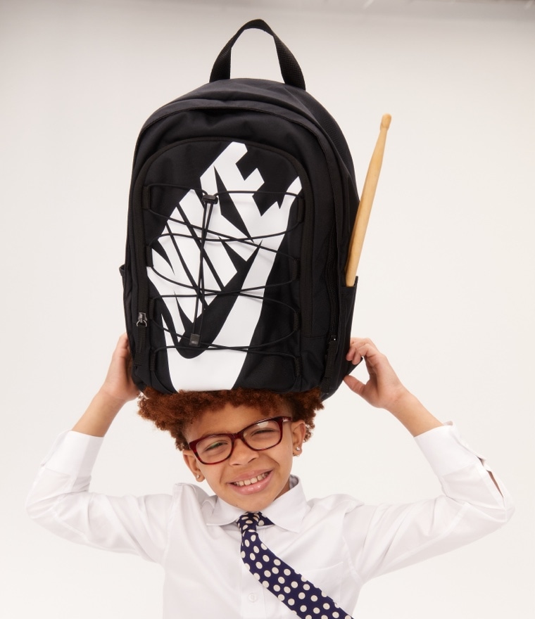 Kid holding black Nike backpack 