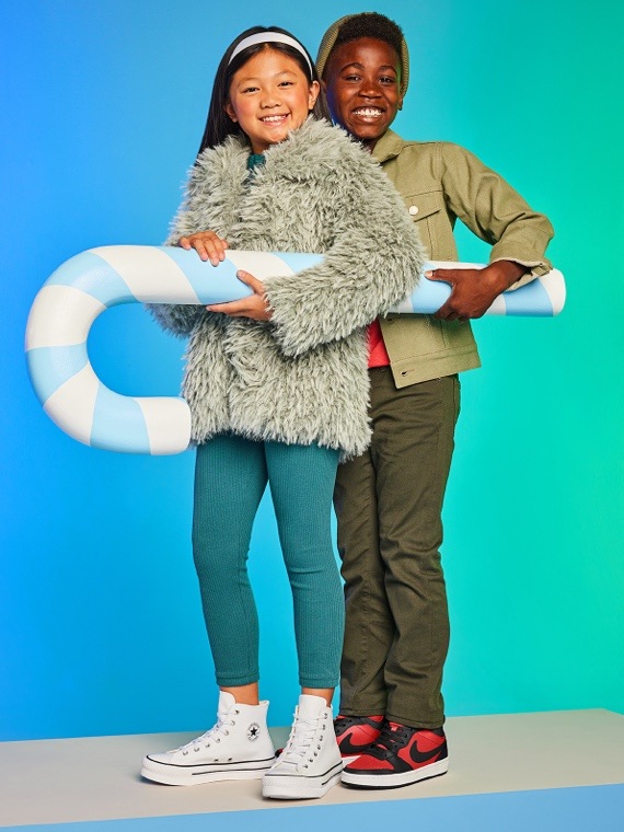 kids holding candy canes wearing holiday clothes and shoes