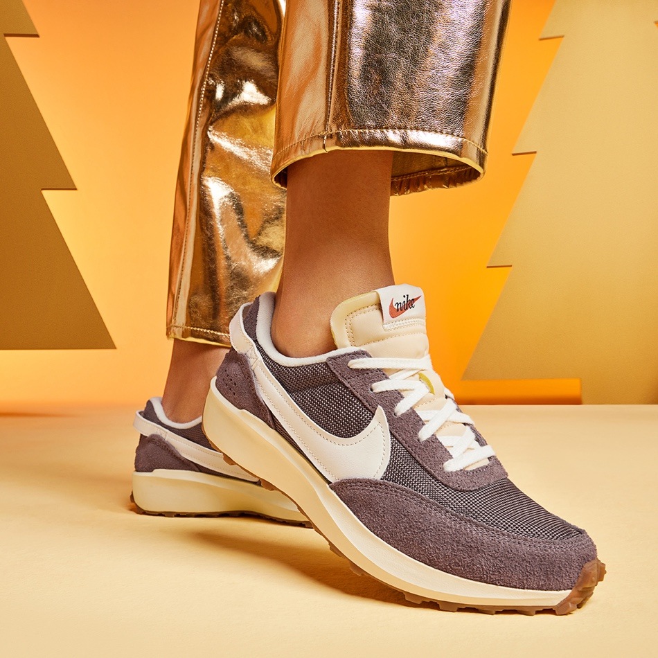 feet of person in gold pants wearing new balance retro sneakers