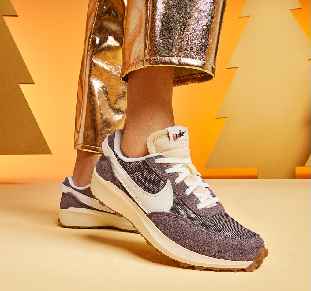 feet of person in gold pants wearing new balance retro sneakers