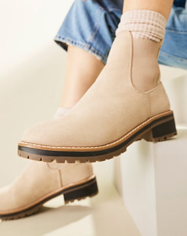 feet of woman in jeans wearing nude chelsea boots with cream socks
