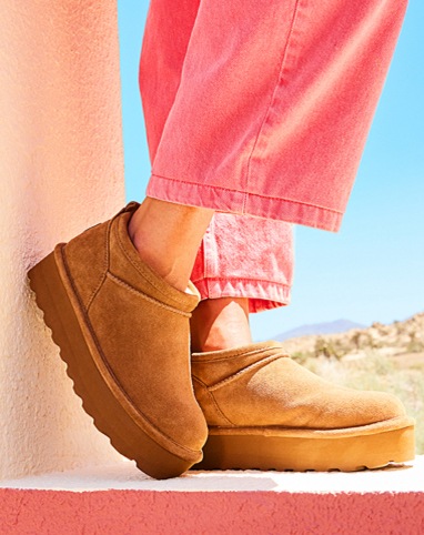 feet of woman in salmon jeans wearing brown comfy slip on platform boots