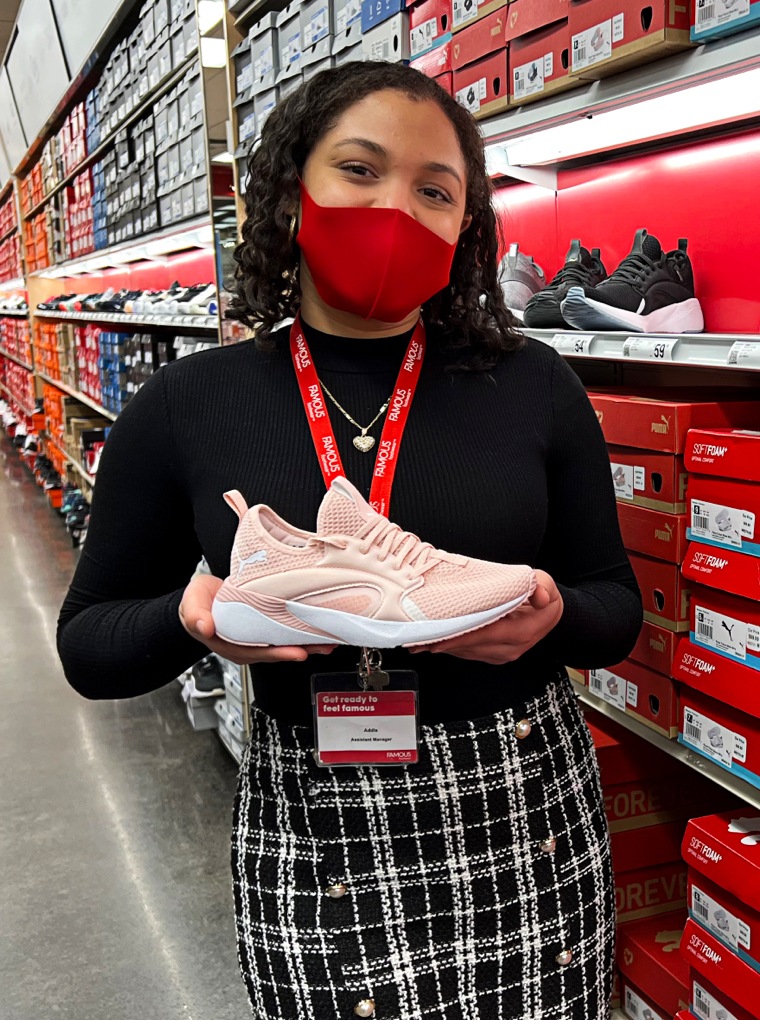 Store associate holding a Puma sneaker