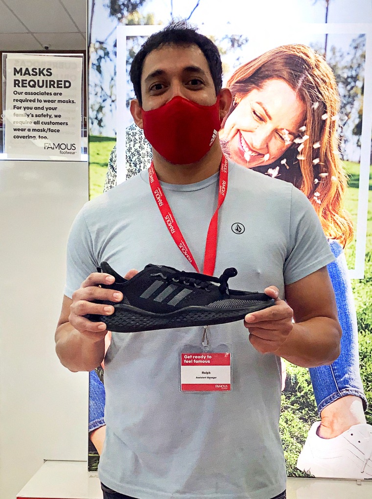 Store associate holding an Adidas sneaker