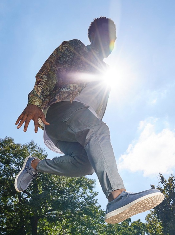 young man jumping with hey dude shoes