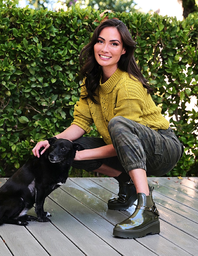 caitlin mchugh petting a dog wearing green ankle boots