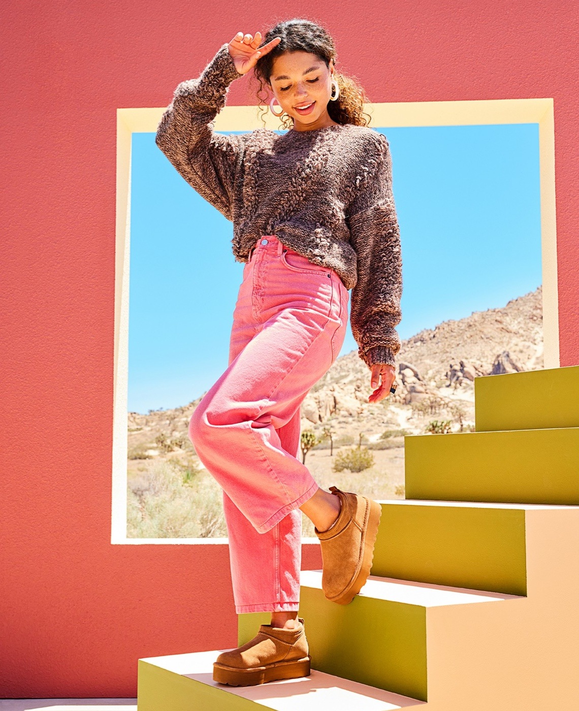 woman in pink jeans wearing brown bearpaw cozy boots