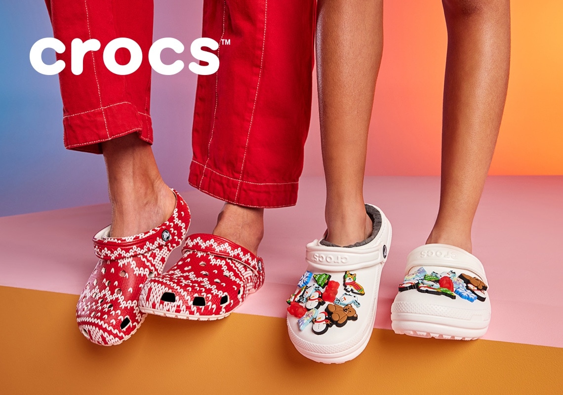 feet of people wearing holiday crocs