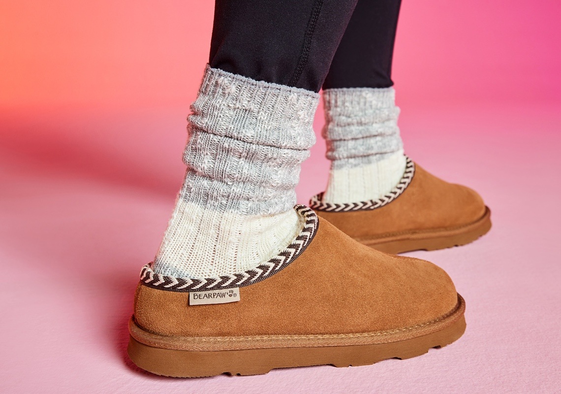 feet of person wearing brown bearpaw slippers with socks 