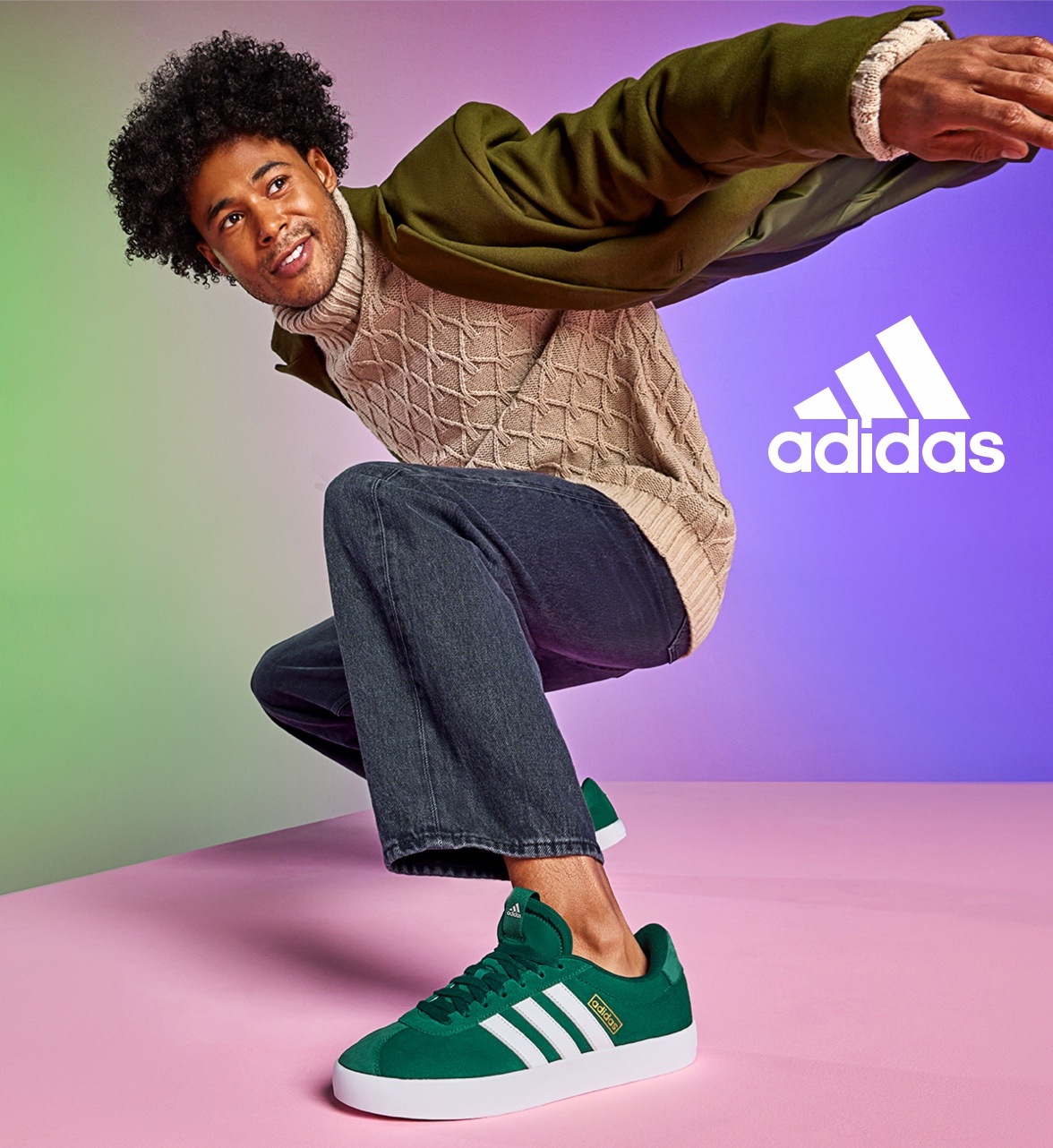 man in gray sweater, green jacket and jeans wearing green adidas court sneakers