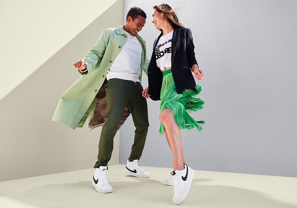 guy and girl wearing white nike tennis shoes with black swoosh