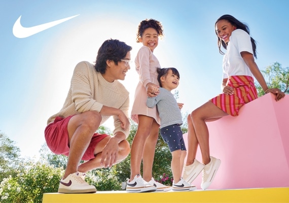 mom, dad and two children wearing nike court sneakers with nike logo in corner