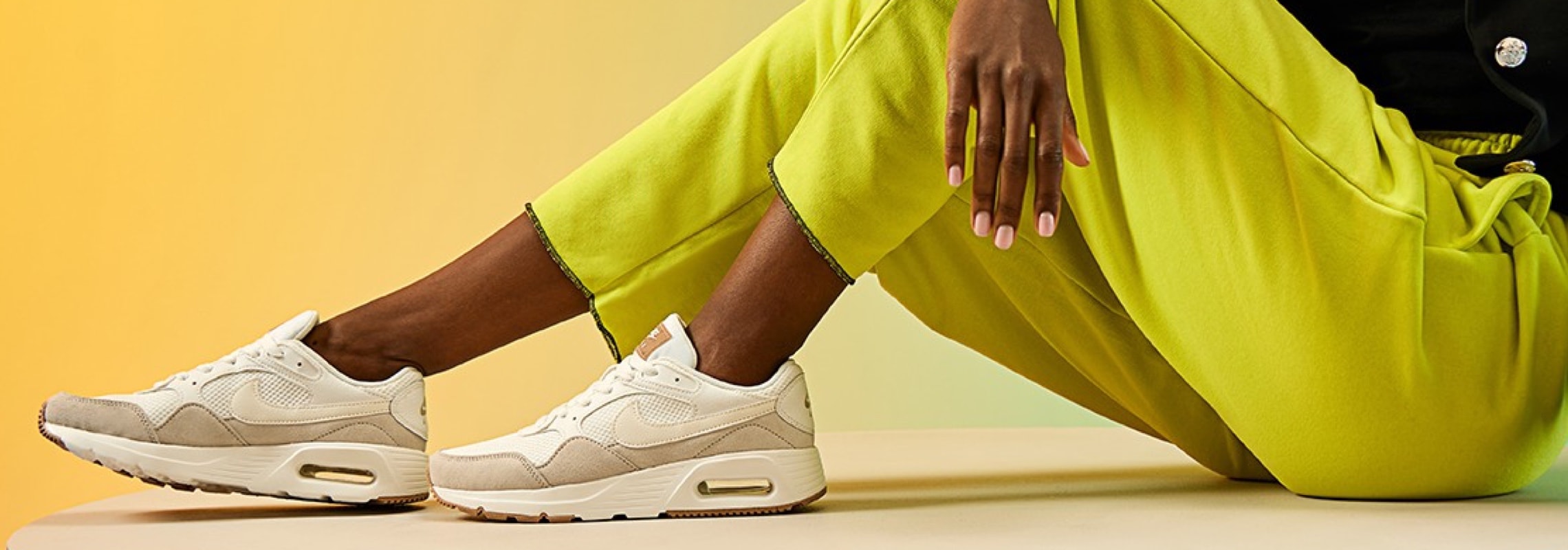 woman in highlighter yellow pants wearing neutral nike air max