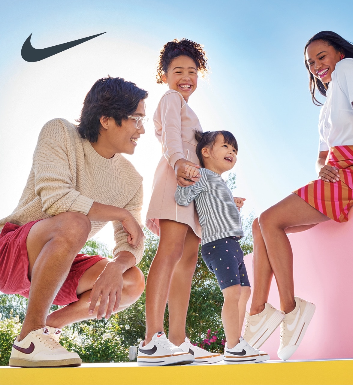 mom, dad and two children all wearing nike court sneakers