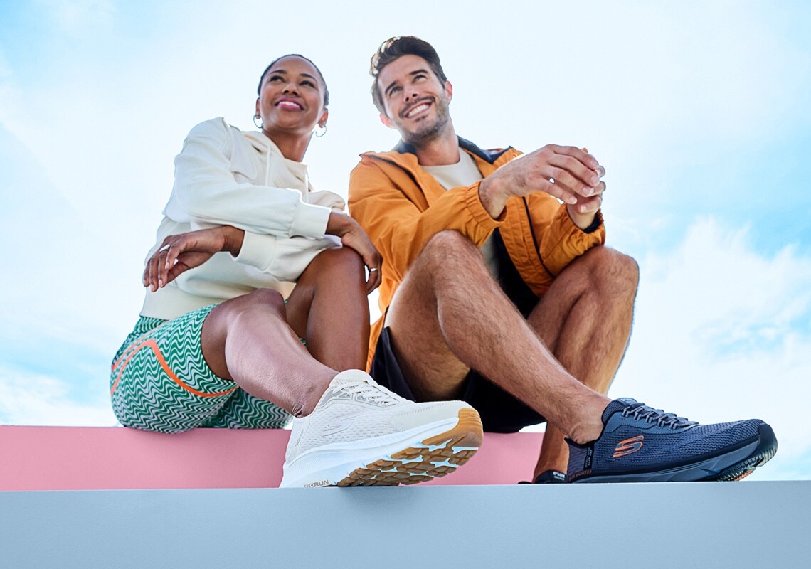 man and woman in athletic clothes wearing skechers slipin running shoes