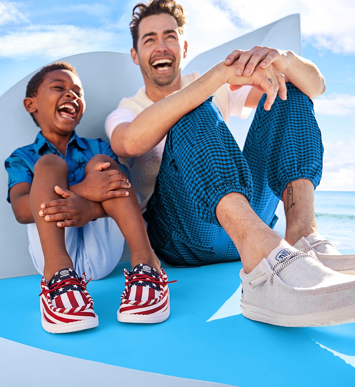 father and son sitting down wearing americana heydude shoes