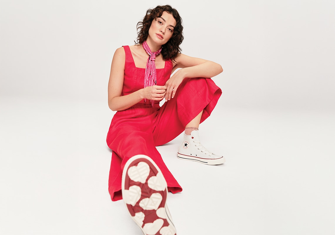 woman wearing valentine's day themed converse shoes