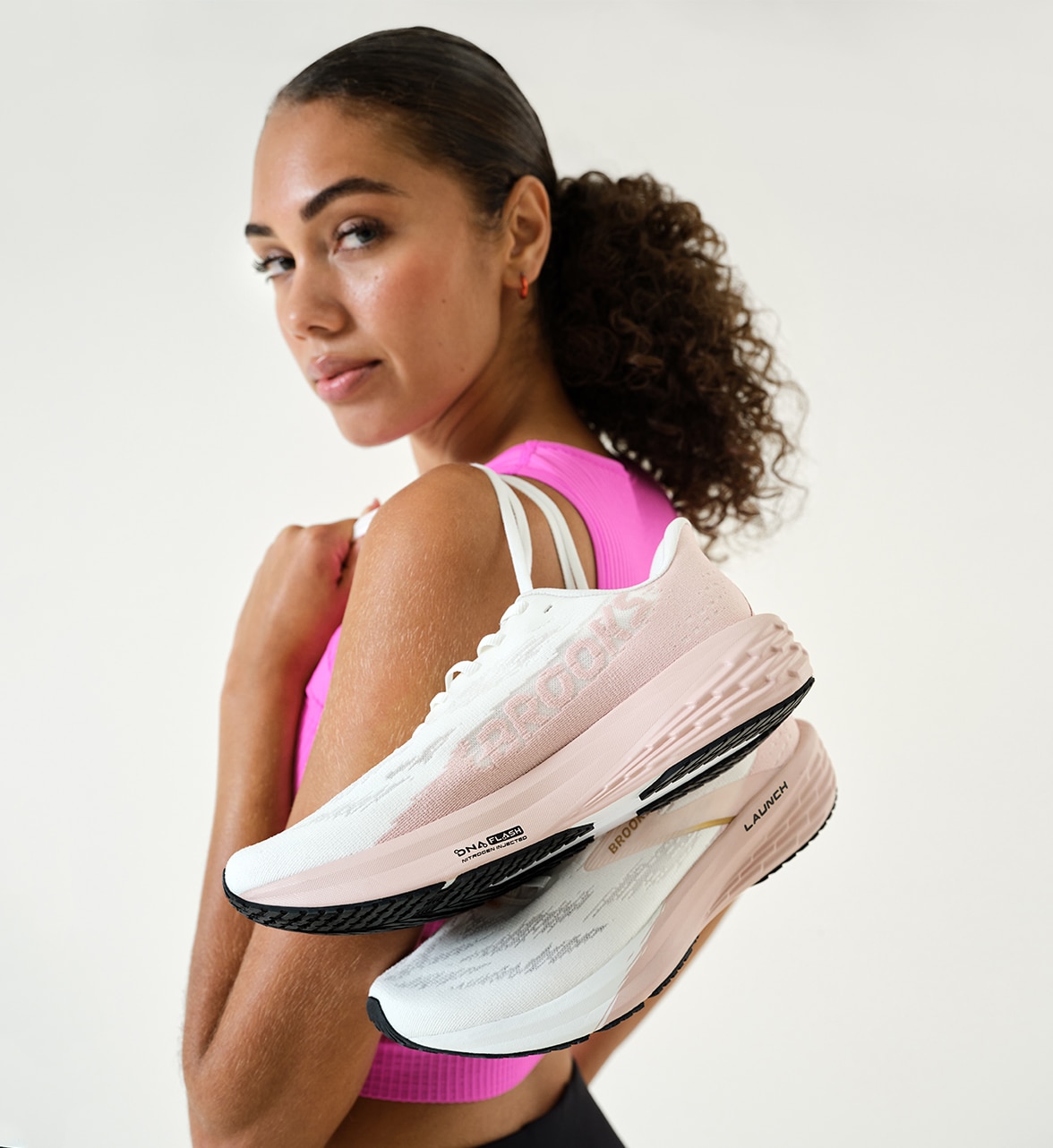 girl holding performance running shoes