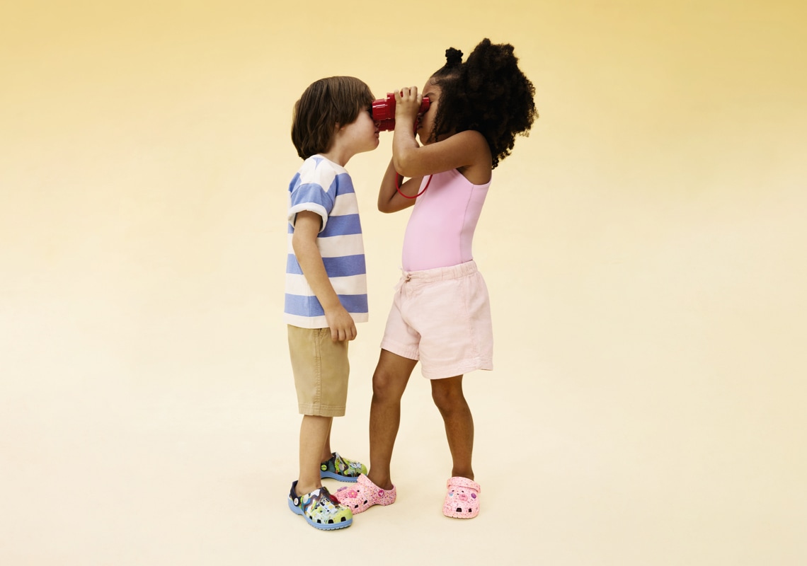 boy and girl looking through the same pair of binoculars wearing crocs