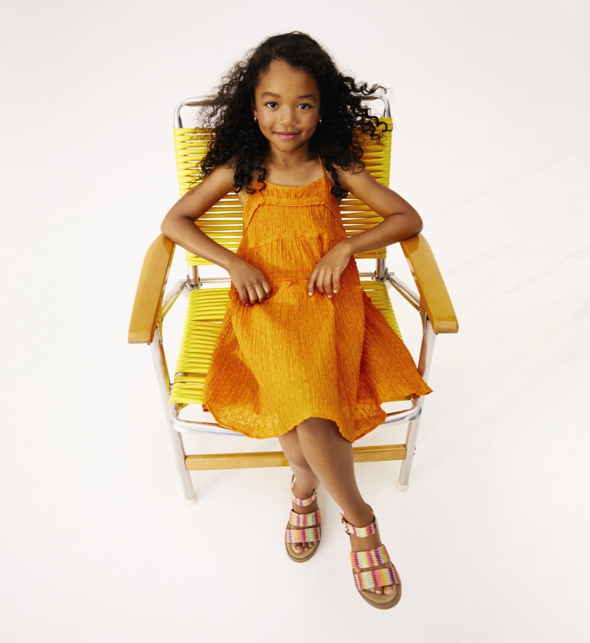 girl sitting in lawn chair wearing sandals