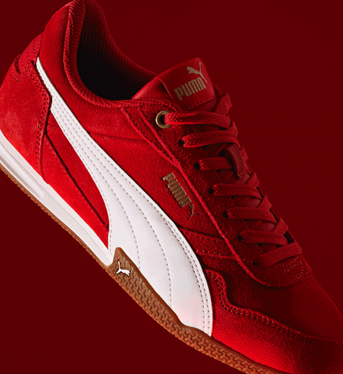 woman in brown t shirt holding a red puma bella donna sneaker