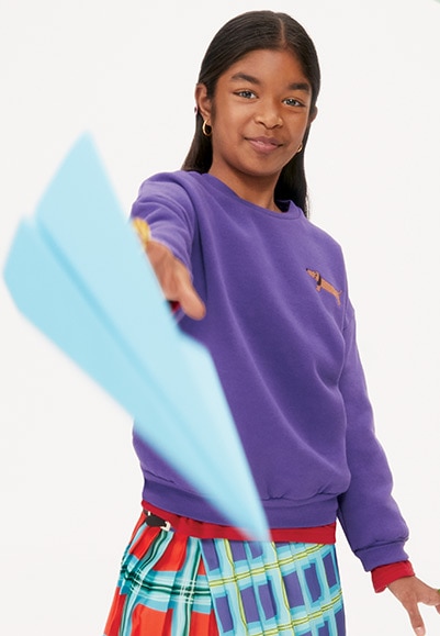 young girl holding a paper airplane
