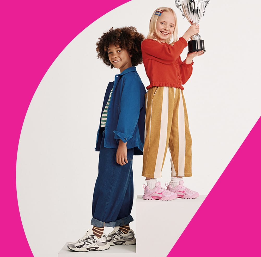 girls wearing nike y2k sneakers holding a trophy