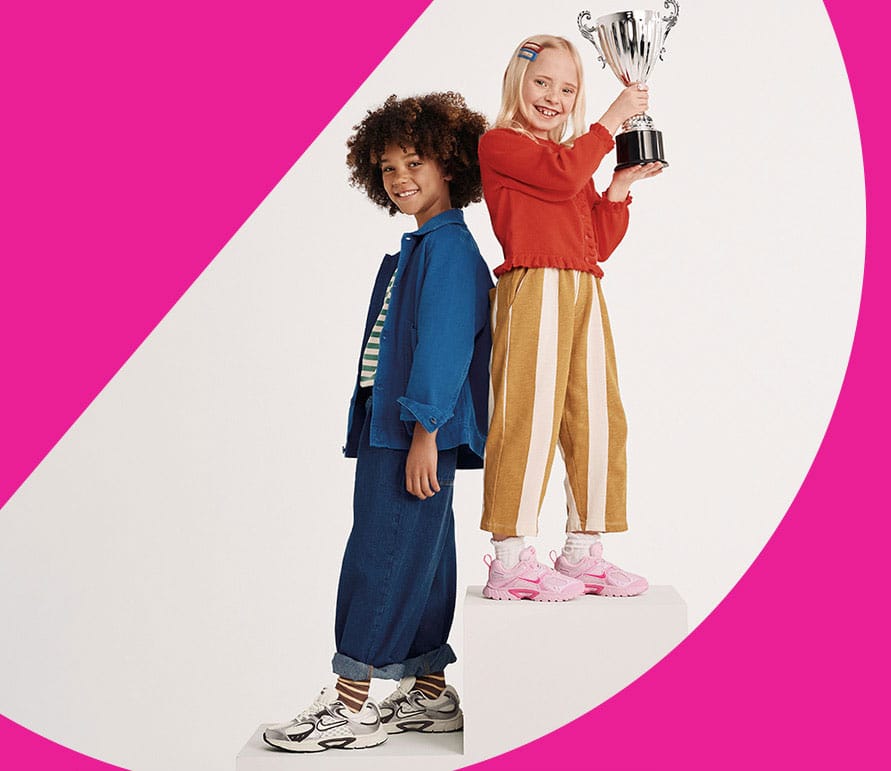girls wearing nike y2k sneakers holding a trophy