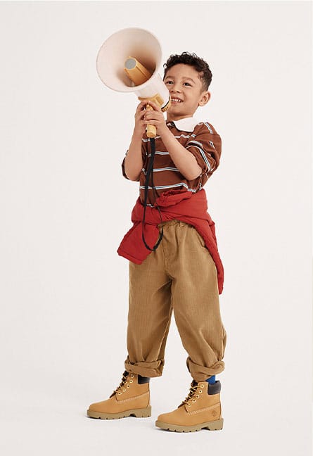 boy wearing timberland boots holding a megaphone