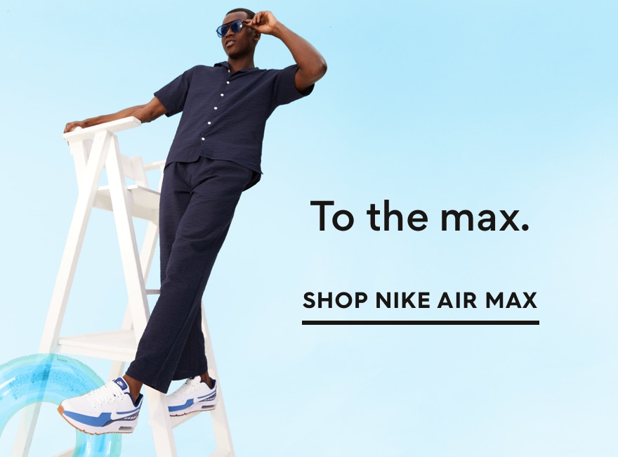 man on ladder wearing blue and white nike air max sneakers posing with sunglasses. to the max. shop nike air max.