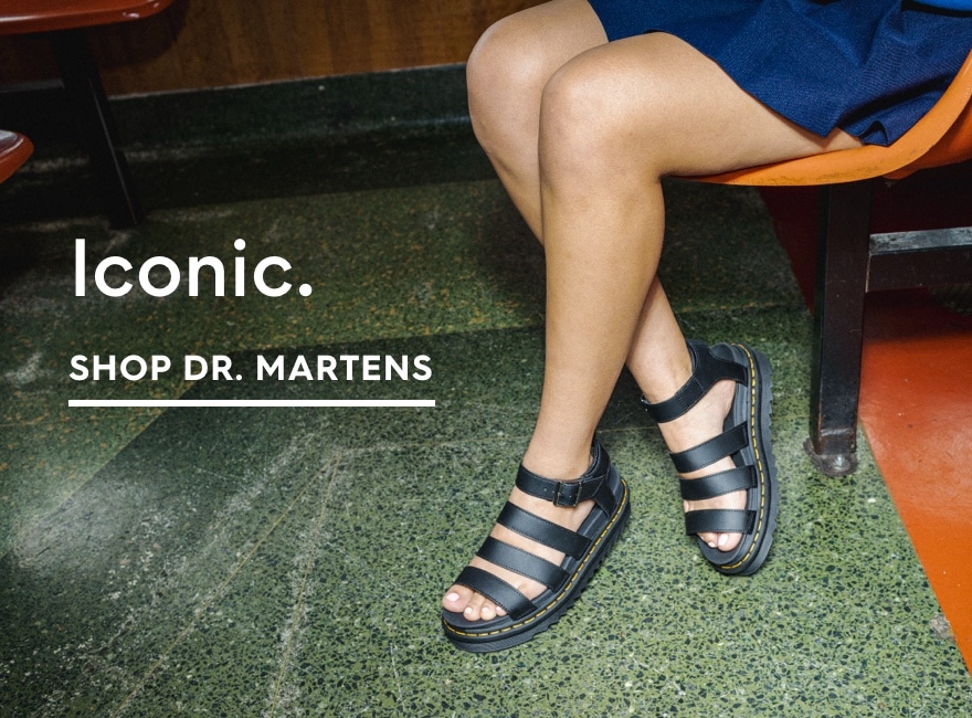 girl in chair wearing Dr. Marten sandals. hop Dr. Martens