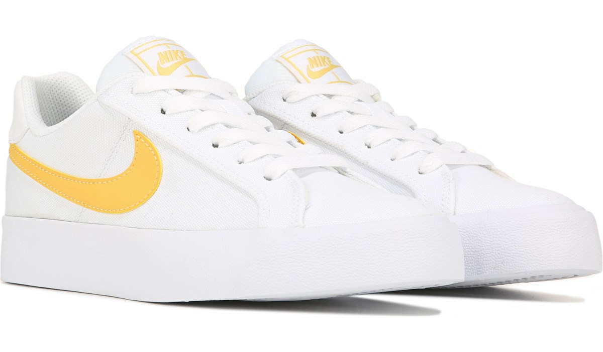 white and yellow nike shoes